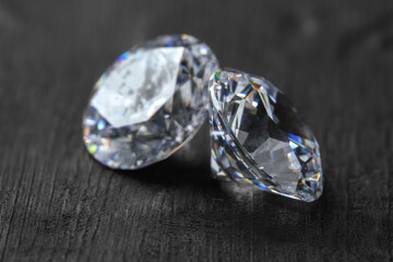 Beautiful shiny diamonds on dark gray table, closeup