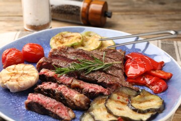 Delicious grilled beef steak with vegetables and spices on table, closeup