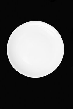 White flat plate on a black background. View from above