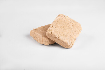 Two pieces of halva on a white background