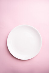 White flat plate on a light pink background. View from above