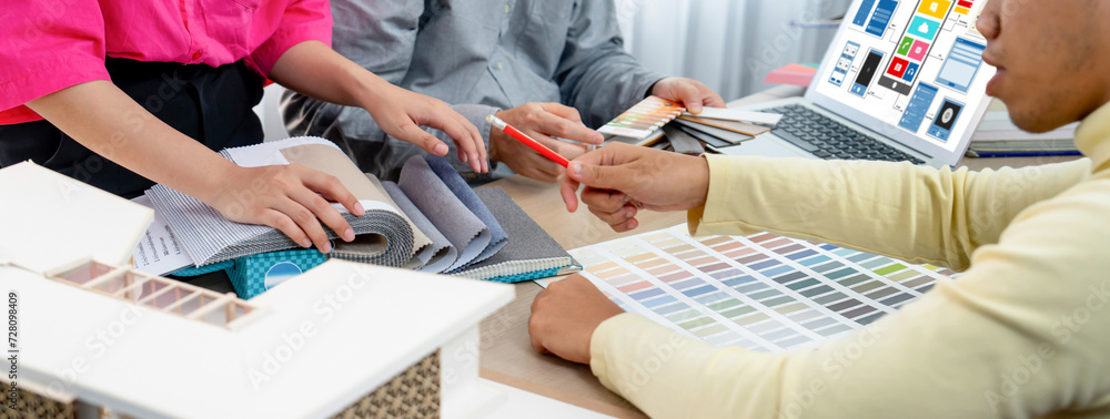 Poster cropped image of interior designer team presents color by using color swatches while laptop displaye