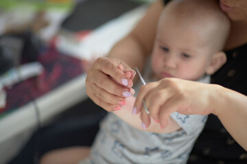 mommy cuts her nails for a child