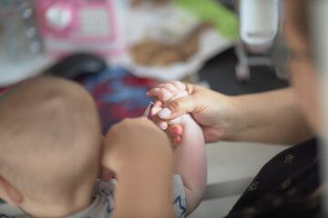 mommy cuts her nails for a child