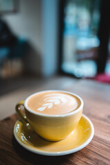 fresh tasty cappuccino or latte coffee with milky foam on wooden table in cafe