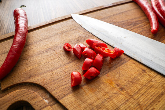 Chopped pepperoni red chili peppers on cutting board with a knife