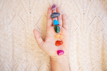 Healing crystals on female hand background, seven chakra stones