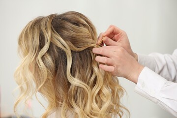 Naklejka premium Hair styling. Professional hairdresser working with client indoors, closeup