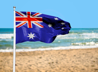 Flag embedded into the sand on the beach. Symbolic of Australia Day. Copy space.