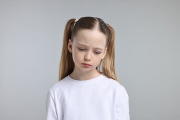 Portrait of sad girl on light grey background