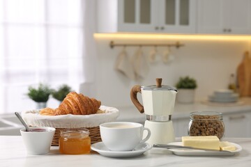Breakfast served in kitchen. Fresh coffee, granola, croissants, jam, butter and honey on white table