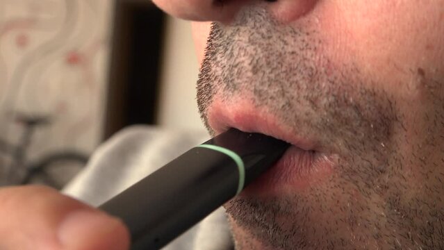 Close up view of man smoking vapor from a vape or electronic cigarette 4k video