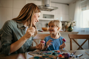 Mom and daughter working together to make beautifully decorated Easter eggs