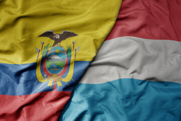 big waving national colorful flag of luxembourg and national flag of ecuador .