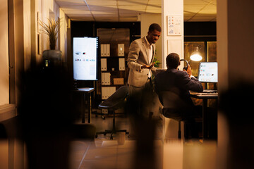 Marketing department employee discussing company strategy, working overtime at financial report...