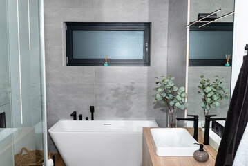 Fototapeta na wymiar LED light strips mounted in the wall in a modern bathroom, visible bathtub.