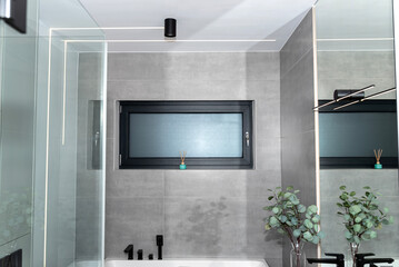 LED light strips mounted in the wall in a modern bathroom, visible bathtub.