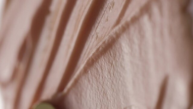 Vertical video. Macro video shooting of cosmetic cream. Beige texture. View from above