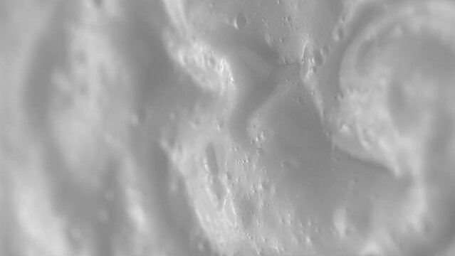 Vertical video. Macro video shooting of facial wash foam. White texture. View from above