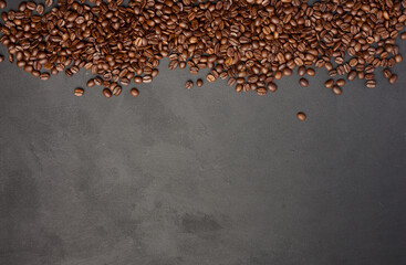 Scattered roasted coffee beans on black background, top view