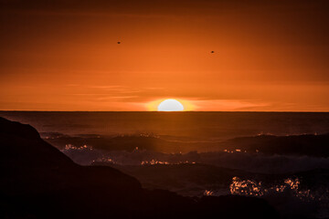 Sun falling behind the waves