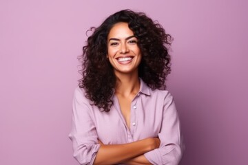 Portrait of a beautiful young woman with curly hair against purple background