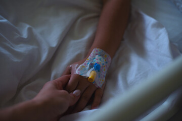 Child's hand with a catheter held by the mother's hand - 728134667