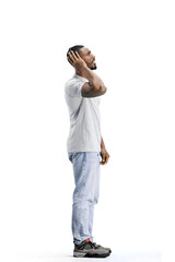 Naklejka premium A man, full-length, on a white background, listening to music with headphones