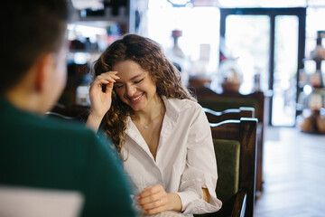 Young woman and man flirting each other in cafe.