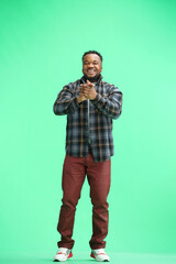 Fototapeta premium A man, full-length, on a green background, claps
