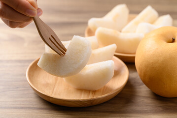 Piece of Asian pear fruit or Nashi pear on wooden bowl ready to eating