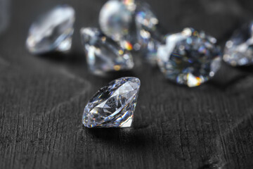 Beautiful shiny diamonds on dark gray table, closeup