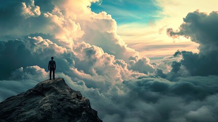 A solitary figure stands atop a rocky peak, silhouetted against a dramatic sky filled with towering clouds illuminated by the light of the setting or rising sun. The clouds exhibit various shades of o