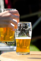 beer glasses scene, hand taking a glass of blonde beer