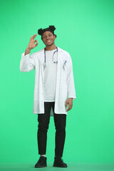 The doctor, in full height, on a green background, shows the ok sign