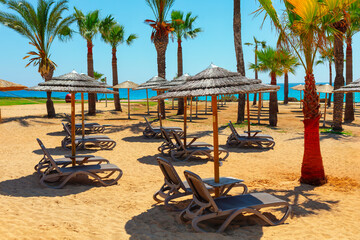 Sun loungers and umbrellas on the sandy beach of the Mediterranean Sea