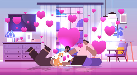 coupe in love with dog using laptop man woman celebrating valentines day living room interior with pink hearts horizontal