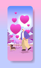 senior man in love walking in park with his little dog grandfather relaxing with pet valentines day celebration concept