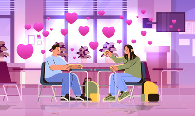 Fototapeta na wymiar school pupils in love sitting at desk elementary education learning process happy valentines day celebration concept classroom interior with pink hearts
