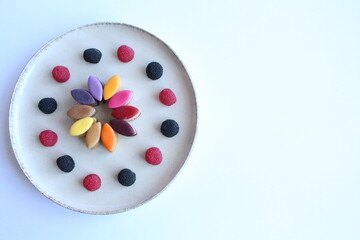 Rainbow candies with raspberries