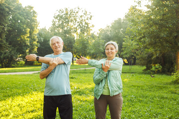 Yoga at park. Senior family couple exercising outdoors.