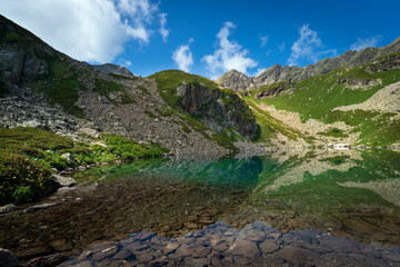 View of the Dukka lake "Rybka" on the Malaya Dukka River on the slopes of the Arkasar ridge in the North Caucasus on a sunny summer day, Arkhyz, Karachay-Cherkessia, Russia © Ula Ulachka