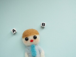 羊毛フェルトの男性とA、Bの選択肢　コピースペース