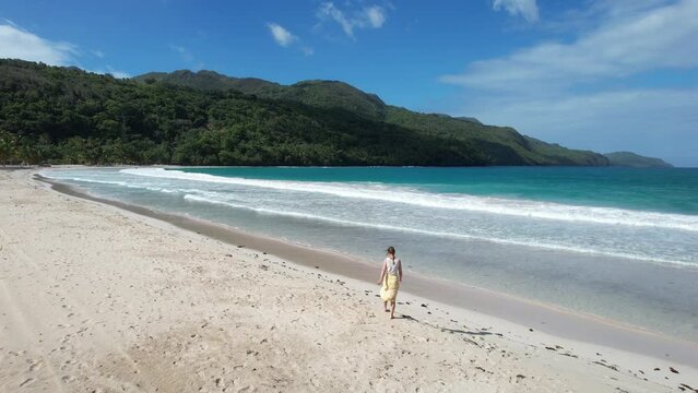 Woman walking on one of the most beautiful beaches on earth - Playa Rincon in the Dominican Republic.