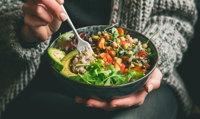 Person in a wool sweater holding a salad bowl