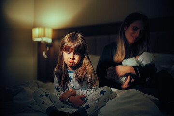 Sad Elderly Sister Being Jealous of the Little Baby with Her mom. Little girl feeling abandoned and...