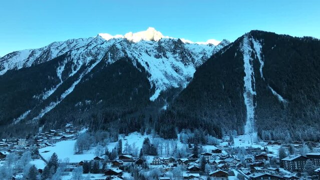 Ski resort of Chamonix, France with the Alps mountains towering above the town on a cold snowy winter day.