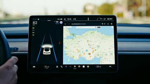 Close-up of Tesla car sensor touchscreen monitor with different apps, functions and capabilities, autonomous navigating system controlling road traffic, speed and battery