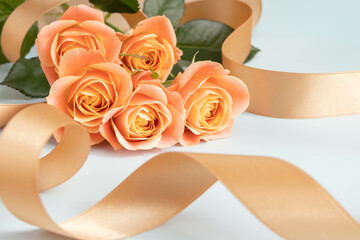 オレンジのバラとゴールドのリボンの愛情のイメージ