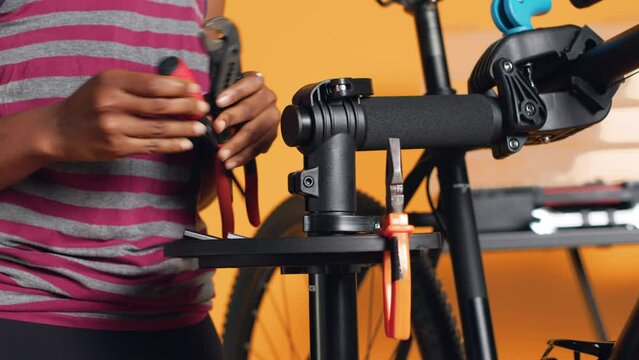 Close up of specialist preparing work tools before starting patching up faulty bicycle parts. Employee arranging screwdriver, pliers and hex wrench on equipment support, handheld camera shot